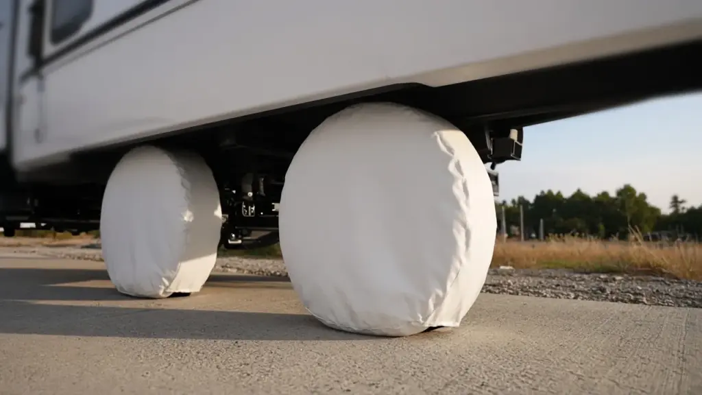 Tire covers on RV wheels parked on a concrete pad