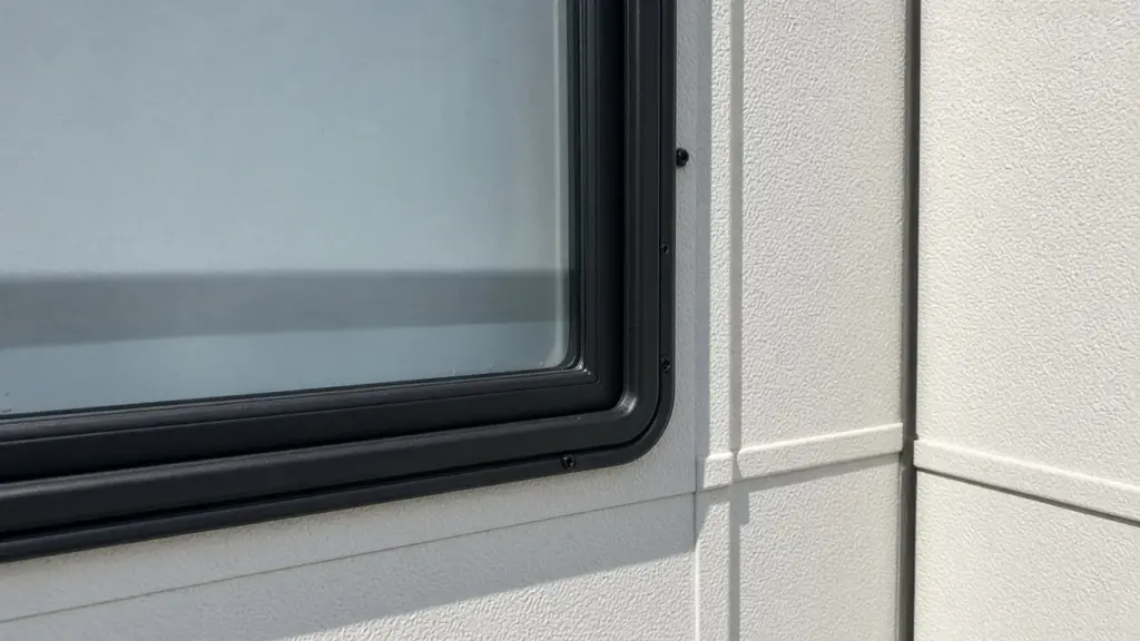 A close-up of an RV window with its rubber seal